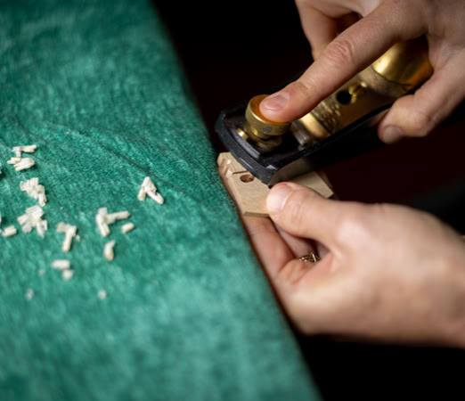 Feinarbeit an einem kleinen Bauteil - h&ouml;chste Pr&auml;zision im Handwerk Geigenbau